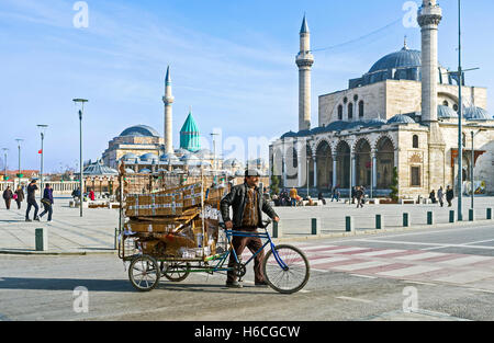 The man transporting the garbage in cargo cycle through the central square of the old town Stock Photo