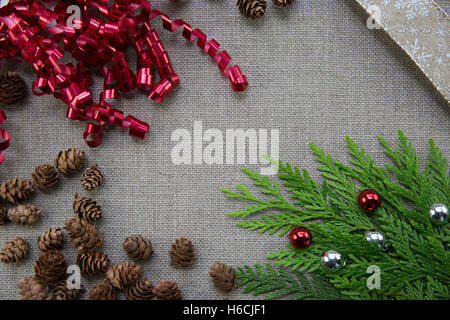 Christmas ribbons and pine cones on linen background with copy space Stock Photo