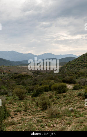 Portrait - Dam wall at Calitzdorp, cloudy with mountains in the background. Stock Photo