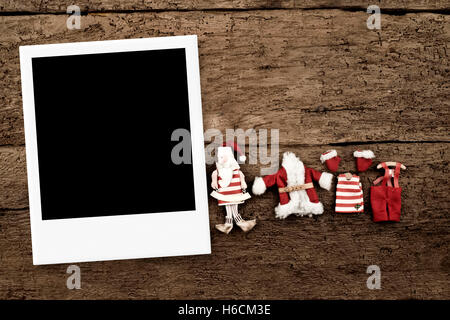 Christmas with one frame for photo with Santa Claus dolls on a wooden background Stock Photo