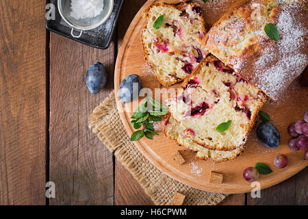 Juicy and tender cupcake with plums and grapes Stock Photo