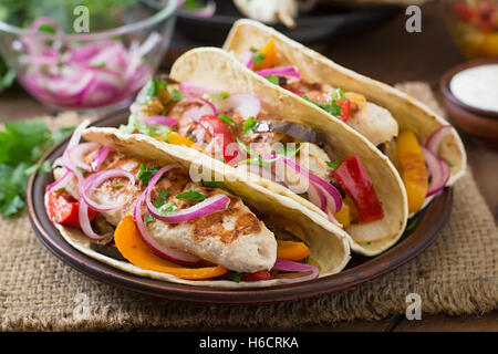Mexican tacos with chicken, grilled vegetables and red onion. Stock Photo