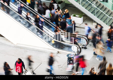escalator with a crowd of people in motion blur at a shopping mall Stock Photo