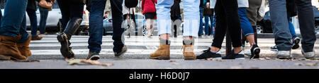 detail of the legs of a crowd of people waiting at the pedestrian crossing Stock Photo