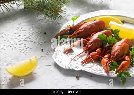 Boiled crawfish, lemon and parsley on a concrete background. Appetizer for Christmas or New Year's table. Food background. The c Stock Photo