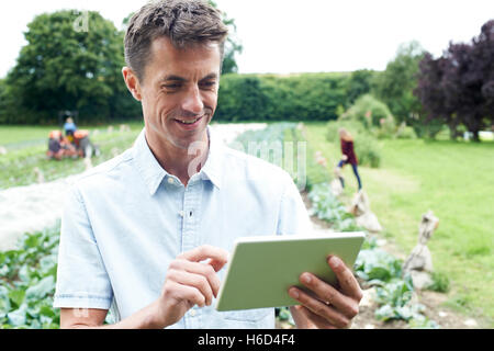Male Agricultural Worker Using Digital Tablet In Field Stock Photo