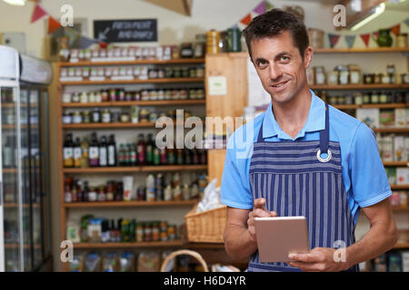 Portrait Of Man Working In Delicatessen Using Digital Tablet Stock Photo