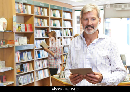 Portrait Of Male Booshop Owner Using Digital Tablet Stock Photo