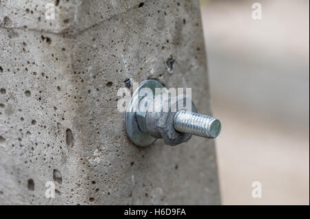 Nut and bolt fixings through a concrete post. Stock Photo
