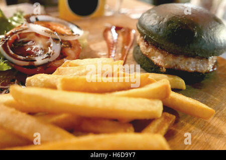 Black hamburger meal dinner set with fries and sauce Stock Photo