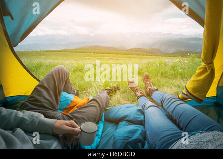 Two people lying in tent with a view of mountains. Altay, Russia. Stock Photo