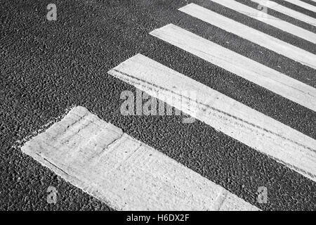Pedestrian crossing road marking zebra, white stripes over gray asphalt pavement, background photo with selective focus Stock Photo