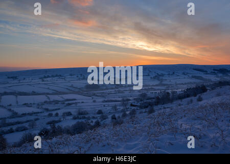 Colourful daybreak sky over Danby Dale with winter snow on the  ground in North York Moors national park Stock Photo