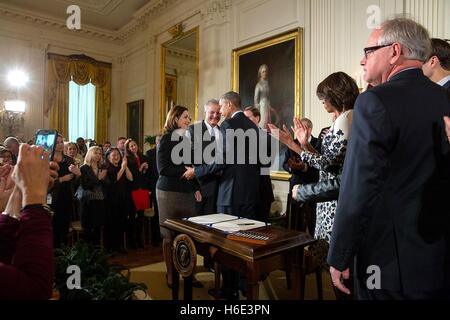U.S. First Lady Michelle Obama applauds U.S. President Barack Obama after he signs the Clay Hunt Suicide Prevention for American Veterans Act in the White House East Room February 12, 2015 in Washington, DC. Stock Photo