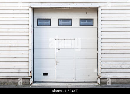 White metal warehouse wall with closed gate, flat background photo texture Stock Photo