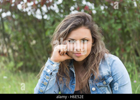 Portrait of cool long haired beautiful teenage girl staring at the camera outdoors. Stock Photo