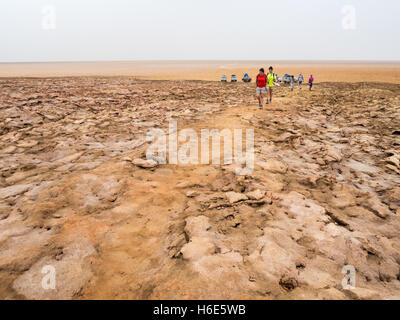 People walking across mineral soil formations around sulfur lake Dallol in Danakil Depression, Ethiopia. Stock Photo