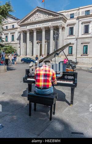Male pianist performing outdoors in a plaza during the Madrid full of pianos day at 8 public locations in Madrid. Stock Photo