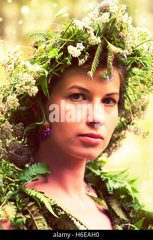 portrait of a young woman wearing a crown of summer wildflowers Stock Photo