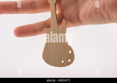 Mini wooden guitar model in hand on a white background Stock Photo