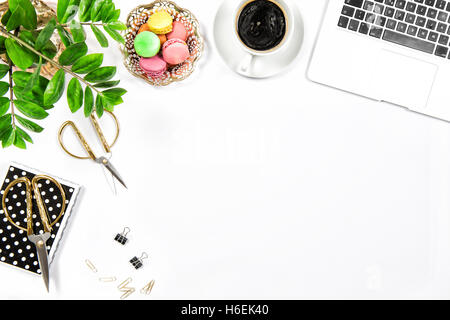Office desk with coffee, cookies, laptop computer and green plant on white table background. Top view. Flat lay Stock Photo