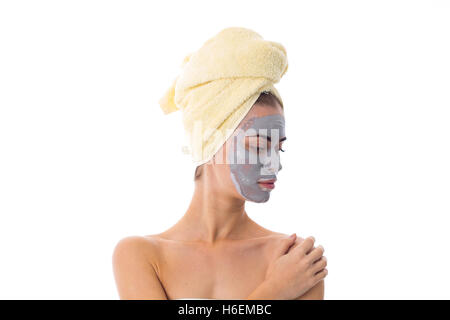 Woman with towel on her head and cosmetic mask on her face Stock Photo