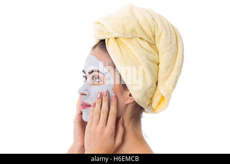 Woman with towel on her head and cosmetic mask on her face Stock Photo