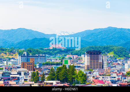Telephoto landscape of Takayama city, Sukyo Mahikari World Headquarters and snow-capped mountain range in layers below a lightly Stock Photo