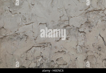 Crumbling grey plaster wall forms an irregular pattern that can be used for backgrounds. Stock Photo