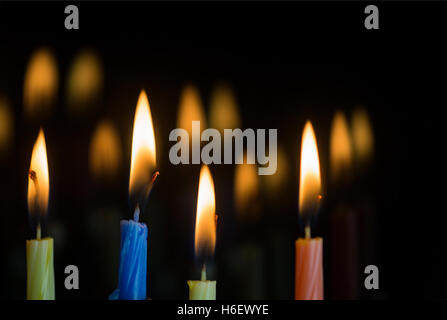 Four lit candles with reflections in glass window at Hanukkah Stock Photo