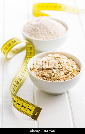 The diet concept. Oatmeal and measuring tape. Stock Photo