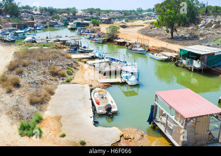 Many fishing boats moored on the banks of the narrow winding riverbed, Liopetri, Cyprus. Stock Photo