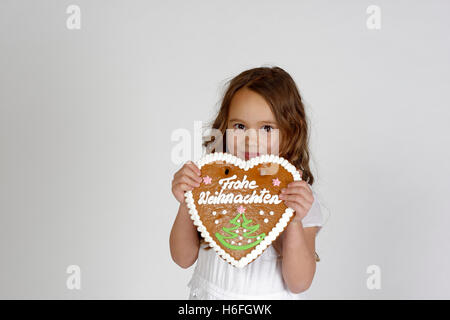 Child, girl with gingerbread heart, frohe Weihnachten, merry Christmas, Upper Bavaria, Bavaria, Germany Stock Photo