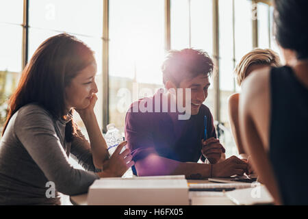 Young man with classmates using laptop in class. university students working on laptop and smiling. Stock Photo