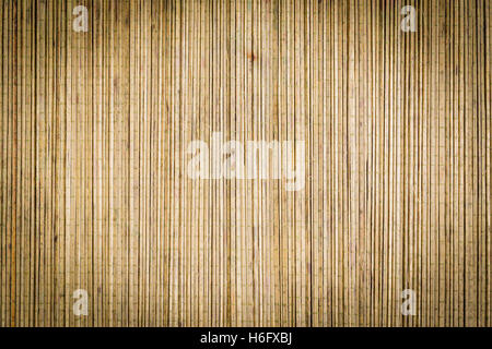 Bamboo mat background surface texture with vignette and antique filter applied to image ideal for Asian or Oriental subjects Stock Photo
