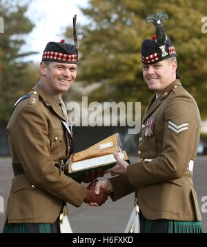 Corporal Warren Grant (right) from The Royal Regiment of Scotland, is presented with an award for best section commander on the course by Reviewing officer Lieutenant Colonel Graeme Wearmouth CO 2 SCOTS, during a parade at Redford Barracks in Edinburgh. Stock Photo