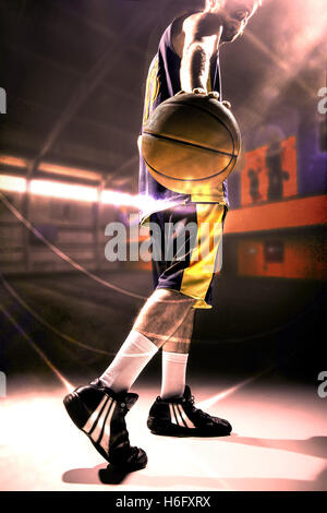 Silhouette view of a basketball player holding basket ball Stock Photo