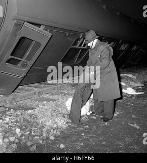 A policeman examines a pair of trousers beside the derailed coach of the 10.30pm London to Edinburgh express, which left the tracks late last night near the village of Conington, Huntingdonshire, England. Stock Photo