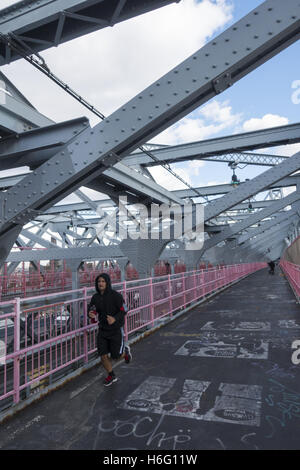 Runner headed towards Manhattan over the Williamsburg Bridge, New York City.