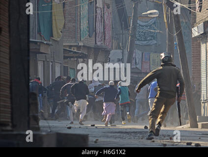 India. 28th Oct, 2016. Kashmri protesters run to save themselves during clashes in Srinagar the summer capital of Indian controlled Kashmir on October 28, 2016. Government authorities foiled the separatist call for marching towards Srinagar grand mosque by imposing curfew in many parts of Srinagar. The Friday congregation prayers were disallowed by government for the 16th consecutive Firday in Srinagar's grand mosque since the killing of rebel commander Burhan Wani. Credit:  Faisal Khan/Pacific Press/Alamy Live News Stock Photo