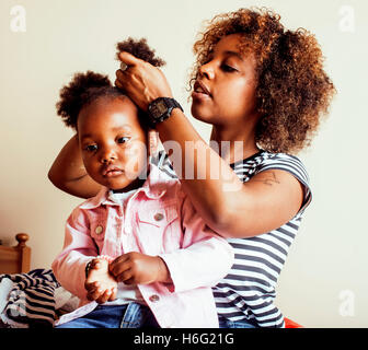 modern young happy african-american family: mother combing daughters hair at home, lifestyle people concept Stock Photo