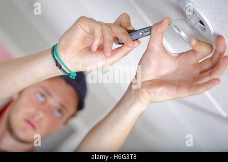 Man replacing spotlight bulb Stock Photo - Alamy