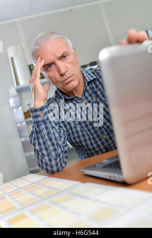 Man with laptop, looking troubled Stock Photo
