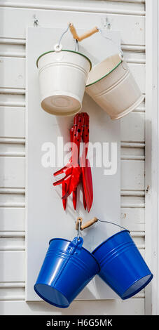 garden tools - shovels and buckets hanging on the wall Stock Photo