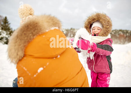 happy family in winter clothes playing with snow Stock Photo