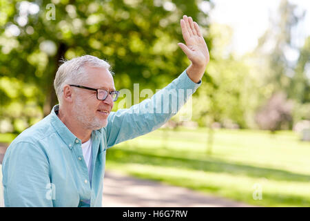 happy senior man waving hand at summer park Stock Photo