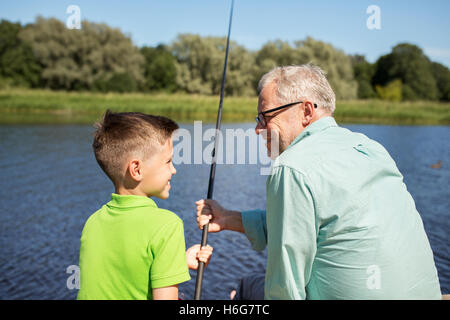 grandfather and grandson fishing on river berth Stock Photo