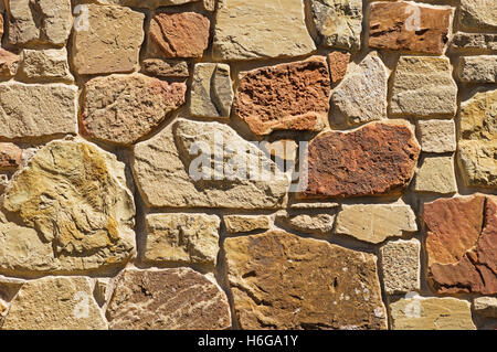 tan and reddish stone wall background texture Stock Photo