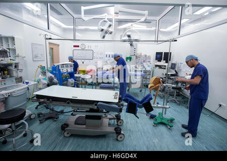 Hospital staff in an operating theatre preparing for an operation Stock Photo