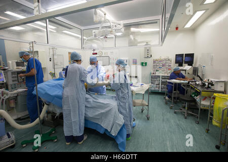 Orthopedic surgeon performing a knee joint replacement operation in a hospital theatre Stock Photo